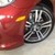 A pixelated image shows a red vehicle with a yellow light and a silver alloy wheel, partially cropped on the right side.