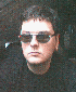 A person wearing dark sunglasses and a black shirt appears in three vertical with slight variations in lighting and positioning