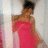 A woman in a strapless pink dress stands against a light background with vertical , her head turned left to right across frames