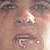 Pixelated close-up of a person's face showing eyes, nose, mouth, and partial cheek with light skin tones and dark eyebrows.