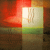 A pixelated image with a central bright white rectangle bordered by red, green, and brown sections. The right side shows faint vertical lines resembling text or symbols.