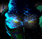 Animated sequence of a figure's lower back and buttocks in blue and green tones with glowing yellow accents, viewed from behind against a dark background.