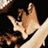 Pixelated close-up of a hand with fingers extended against dark background, showing partial arm and shoulder in light-colored clothing.