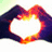 Animated heart-shaped hands with glowing orange-yellow edges against a white background, transitioning from a full heart to a partial heart shape.