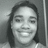 Pixelated grayscale portrait of a person with shoulder-length hair, closed eyes, and a broad smile showing teeth, set against a gradient background.