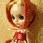Four distinct static images of a doll with large eyes and blonde hair, each in different outfits and backgrounds.