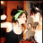 Pixelated image of two figures in close embrace, one with green hair and dark clothing against warm-toned background.