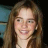 A static pixelated image of a person with long brown hair, light skin tone, and visible facial features including eyes, nose, mouth, and ears.