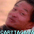 A pixelated close-up of a person's face with a blurred background, featuring light blue text at the bottom reading 'CARY' TAGAWA' in a digital font.