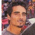 A 50x50 pixel animated buddy icon featuring a contact sheet of two frames showing a person in front of a crowd, with green text reading "Original Icons .com" on the right side.