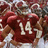 Pixelated image of a person in a maroon jersey with white number 14, holding a football, against a blurred background.