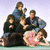 Group of people in casual poses on left, purple background with white text 'The Breakfast Club' on right.