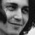 Black-and-white pixelated image of a person with long hair, showing slight facial expression changes across frames and partial text overlays.