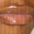 A pixelated close-up of lips with a glossy sheen, showing subtle color variations from light brown to pinkish-red tones.