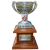 Pixelated trophy with silver cup, wooden base, and red emblem on stem against gray background.