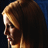 A woman with long light brown hair in profile view, transitioning from a clear side face to blurred motion against dark blue background.