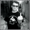 Black-and-white photo of a person in a narrow alley wearing dark sunglasses and a black t-shirt with a white graphic, holding up the middle finger while text at bottom reads 'good fucking bye'.