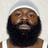 A pixelated image of a person with a dark beard wearing a white headband and tank top, set against a light background with text overlays.