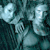 Pixelated static image of two light-colored figures against a dark teal background with visible dithering and low-resolution artifacts.
