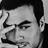 Black-and-white pixelated static image of a person's face with visible hair, eyebrows, eyes, nose, mouth, and ear in grayscale tones.