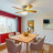 Pixelated static image of an interior room with red curtains, a table, chairs, and a window with a view of a building exterior.
