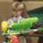 Pixelated image of a person holding a large green and yellow object, with text on bright green backgrounds.