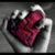 A hand holds a red heart-shaped object with visible text, set against a gray background.
