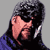 Pixelated static icon of a person with dark hair and sunglasses, wearing a blue garment against a gray background.