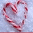 A pixelated heart shape formed by red and white striped candy canes on a light blue background.