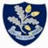 A shield-shaped icon with a blue background features a white oak leaf with yellow highlights and a white wave-like pattern at the bottom, next to text reading "Forest School Girl" on a dark blue background.