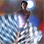 Pixelated figure in dark top and blue pants stands on white clouds with a bright light behind, against a blurred background.