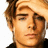 Pixelated close-up of a person's face with light brown hair, closed eyes, and neutral expression against white background.