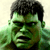 Pixelated green-skinned humanoid face with dark hair and stern expression on light background