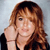 A pixelated portrait of a person with long brown hair resting their chin on a hand, wearing a dark top against a light gray background.