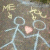 Pixelated static icon featuring two light blue stick figures with a pink heart between them, set against a muted brown background with faint yellow text elements.