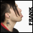 Pixelated profile view of a person with short brown hair, visible ear, neck tattoo, and red-trimmed dark clothing against white background.