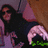 A pixelated image shows a person with long dark hair wearing a black top, holding a pink object near their face against a brown background.