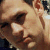 Pixelated close-up of a person's face with light skin tone, dark hair, and visible facial features including eyes, nose, and mouth.