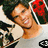 Pixelated image of a person with dark hair wearing a white shirt and red headband, smiling against blurred background.