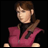 Pixelated character in pink sleeveless top with brown hair tied back, standing against black background with white text "AnimeIM" and "com" on right side.