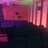 Pixelated image with dominant pink and purple hues, featuring vertical light streaks and dark lower sections, no visible text or distinct subjects.