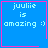 Blue square with pink border containing white text 'juulie is amazing :)' and a small pink heart or star symbol in the bottom-right corner.