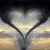 A heart-shaped silhouette formed by hands against a sunset sky, with the lower portion showing two hands cupping a glowing orange and yellow heart.