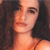 Pixelated close-up of a person with dark hair and light skin, wearing a thin dark necklace, against a dark background.