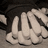 A grayscale animated sequence showing a hand with fingers curled into a fist, transitioning from a relaxed grip to a clenched fist against a dark background.
