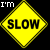 Static pixelated yellow diamond-shaped warning sign with black border and text, featuring "SLOW" in bold letters on the main face and "I'M" in white text at top-left corner against a solid black background.