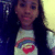 Pixelated static image of a person with long dark hair wearing a light-colored shirt featuring a red heart and rainbow stripes against a dark background.