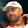 A person wearing a white cap with a red logo, holding a microphone, with red and green text below the neck.