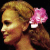 Pixelated profile of a person with light brown hair and a pink flower accessory, next to stylized text on black background.