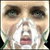 Pixelated static image of a person's face with visible eyes, nose, mouth, and hands near the cheeks in a close-up composition.